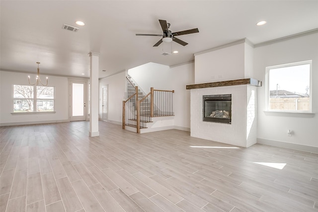 unfurnished living room with ornamental molding, light hardwood / wood-style floors, and ceiling fan with notable chandelier