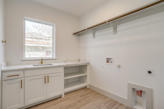 clothes washing area featuring hookup for a washing machine, sink, cabinets, and hookup for an electric dryer