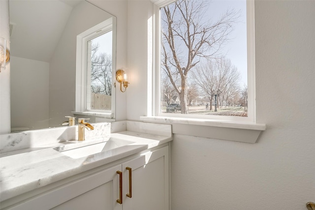 bathroom featuring vaulted ceiling, a wealth of natural light, and sink