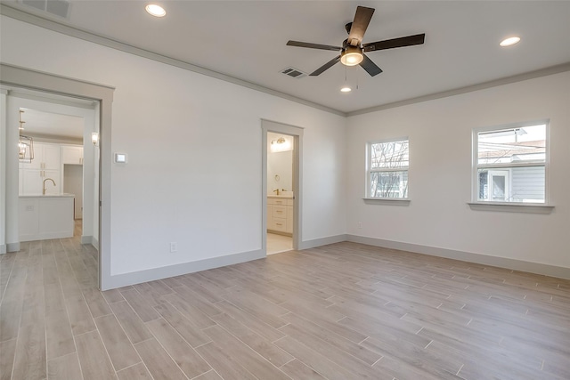 unfurnished bedroom featuring ceiling fan, light wood-type flooring, crown molding, and connected bathroom