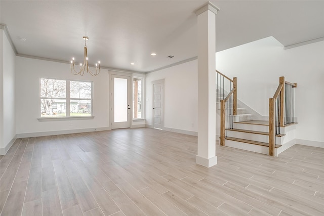 unfurnished living room with a notable chandelier, crown molding, and light hardwood / wood-style flooring