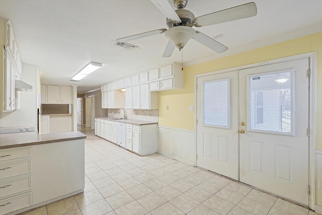 kitchen with white cabinetry, ceiling fan, white dishwasher, light tile patterned floors, and crown molding