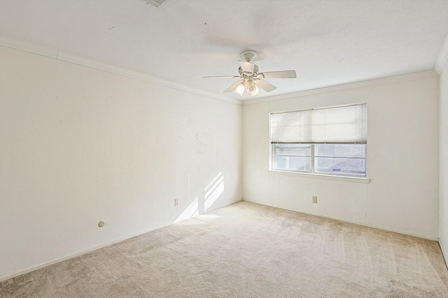 carpeted empty room with ceiling fan and ornamental molding