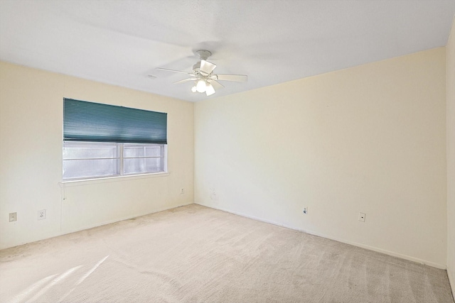 spare room with ceiling fan and carpet