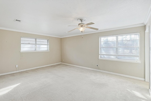 carpeted empty room featuring ceiling fan, a textured ceiling, and crown molding