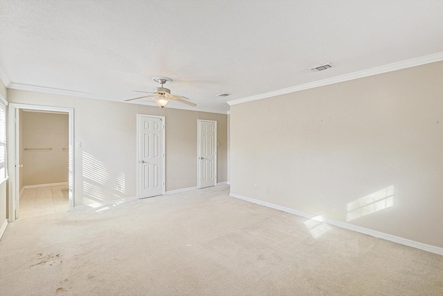 carpeted spare room with ceiling fan and crown molding