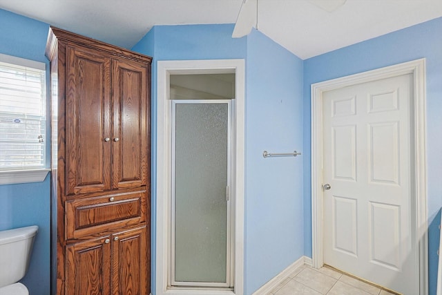 bathroom with a shower with shower door, tile patterned floors, a wealth of natural light, and toilet