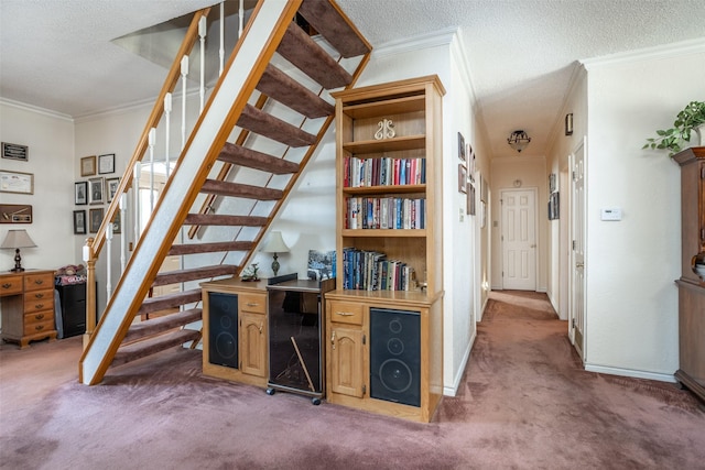 staircase with a textured ceiling, ornamental molding, and carpet floors