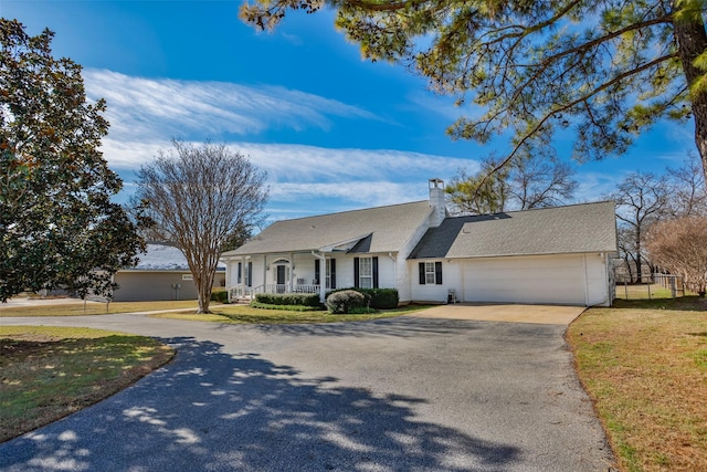 ranch-style house with a garage, a front yard, and a porch