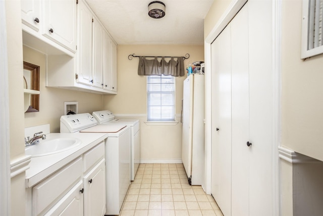 washroom with cabinets, sink, and washing machine and clothes dryer