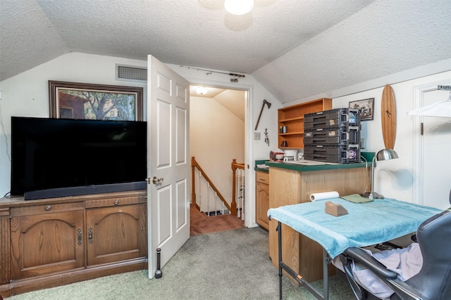 kitchen featuring a textured ceiling, light carpet, and lofted ceiling