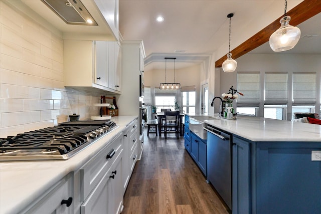 kitchen featuring tasteful backsplash, white cabinetry, hanging light fixtures, blue cabinetry, and stainless steel appliances