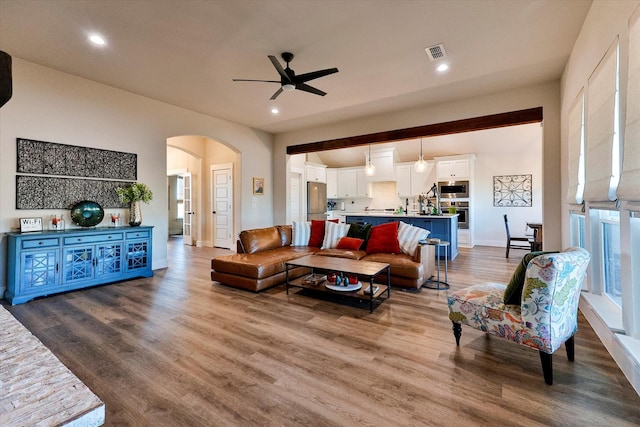 living room featuring ceiling fan and hardwood / wood-style flooring