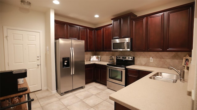 kitchen with light tile patterned floors, appliances with stainless steel finishes, backsplash, and sink