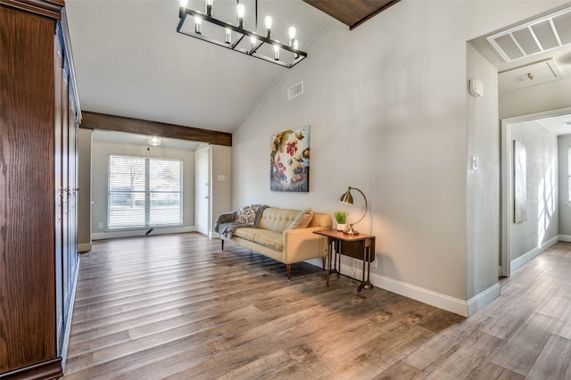 living room with beam ceiling, high vaulted ceiling, a chandelier, and light wood-type flooring