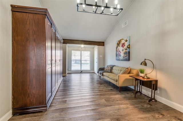 interior space featuring dark wood-type flooring, a chandelier, and vaulted ceiling