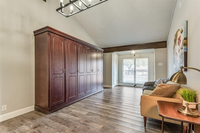 sitting room featuring an inviting chandelier, vaulted ceiling, and light wood-type flooring