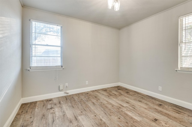 unfurnished room with ornamental molding, a healthy amount of sunlight, and light hardwood / wood-style flooring