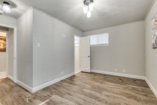 unfurnished room with hardwood / wood-style flooring and crown molding