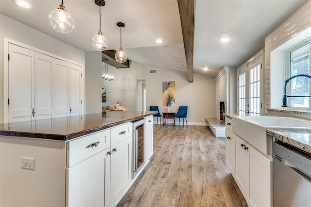 kitchen with lofted ceiling, dishwasher, hanging light fixtures, wine cooler, and white cabinets