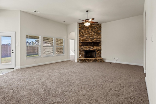 unfurnished living room featuring ceiling fan, light colored carpet, a stone fireplace, and high vaulted ceiling