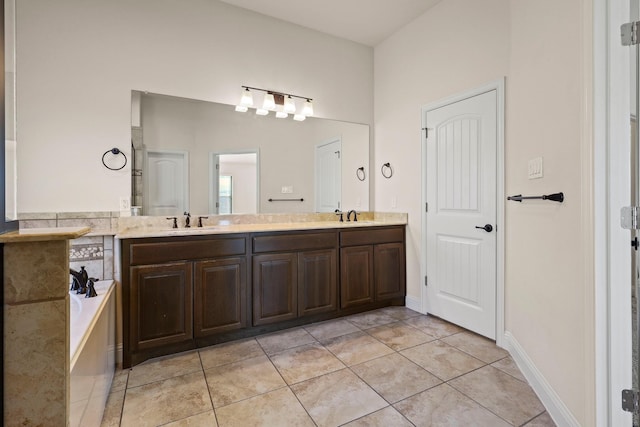 bathroom featuring tile patterned floors, a washtub, and vanity