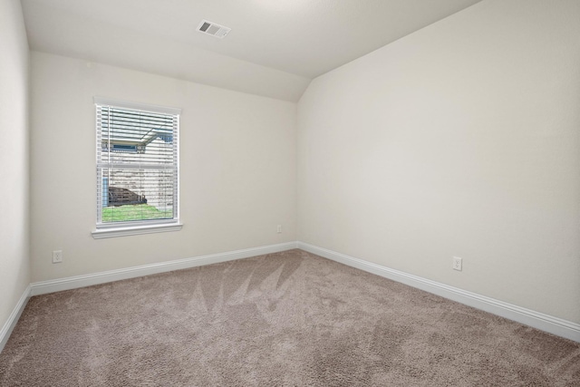 unfurnished room featuring lofted ceiling and carpet flooring