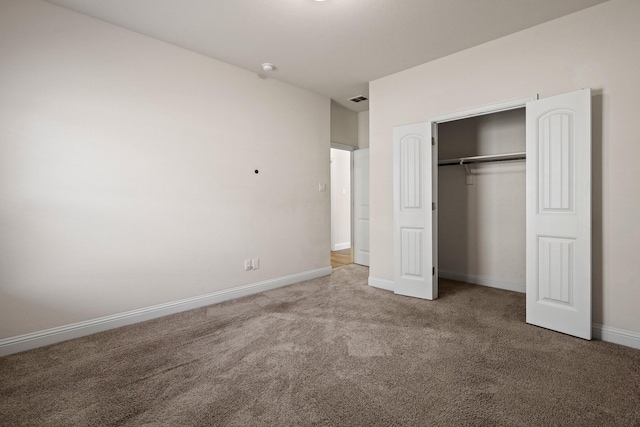 unfurnished bedroom featuring carpet and a closet