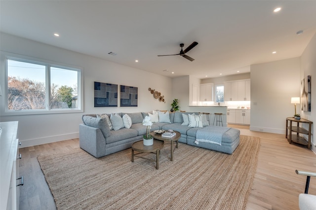 living room with light wood-type flooring and ceiling fan