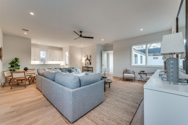 living room featuring ceiling fan and light wood-type flooring