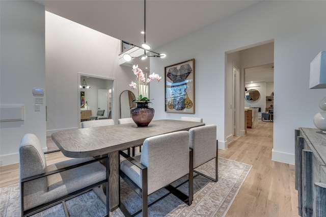 dining space with light hardwood / wood-style flooring and an inviting chandelier