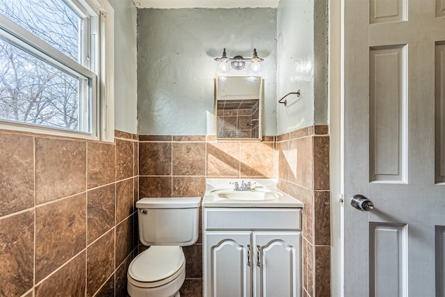 bathroom featuring tile walls, toilet, and vanity