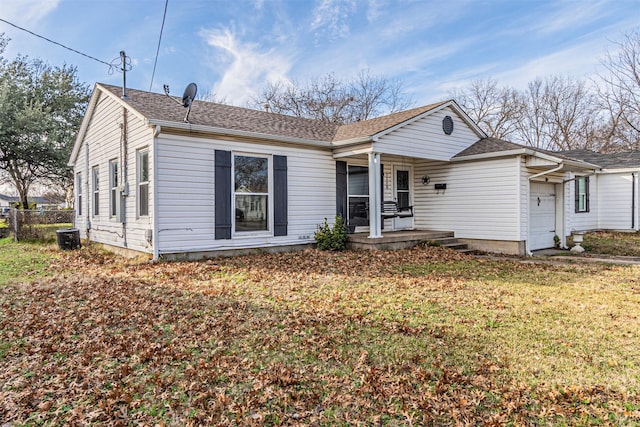 single story home featuring a front yard, a garage, and a porch