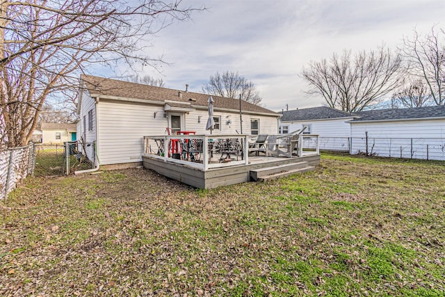 rear view of house with a lawn and a deck