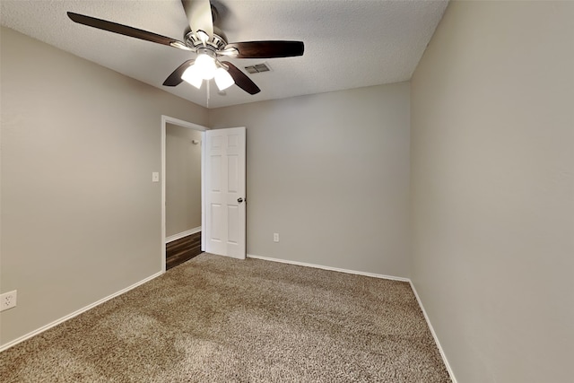 carpeted empty room with a textured ceiling and ceiling fan