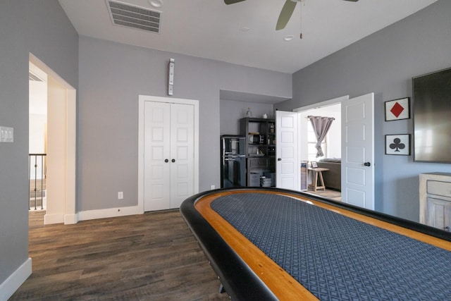 bedroom with a closet, dark hardwood / wood-style floors, and ceiling fan