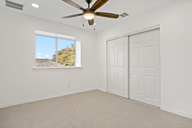 unfurnished bedroom with ceiling fan, a closet, and light colored carpet