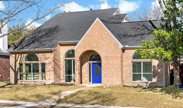 english style home featuring a front yard