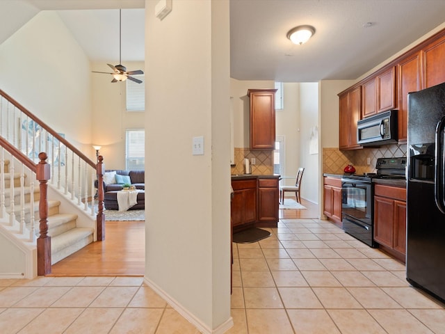 kitchen with light tile patterned floors, ceiling fan, decorative backsplash, high vaulted ceiling, and black appliances