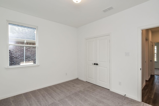 unfurnished bedroom with a closet and carpet floors