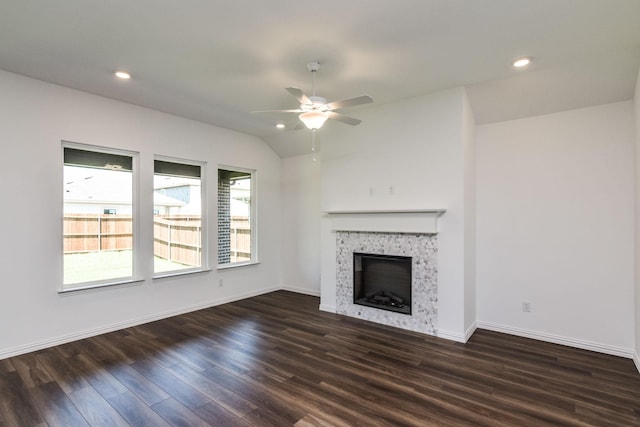 unfurnished living room featuring ceiling fan, dark wood-type flooring, a tile fireplace, and lofted ceiling