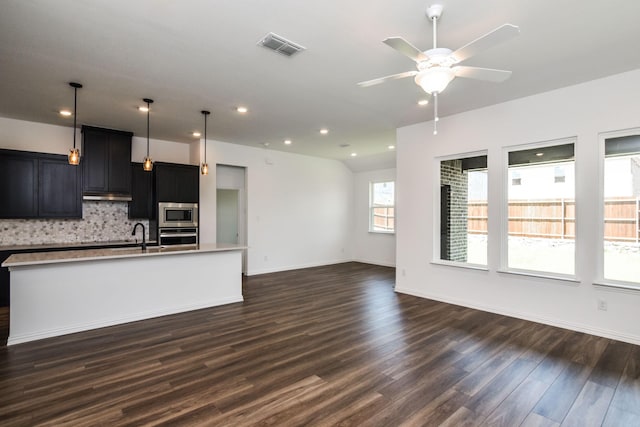 unfurnished living room with ceiling fan, dark wood-type flooring, and sink