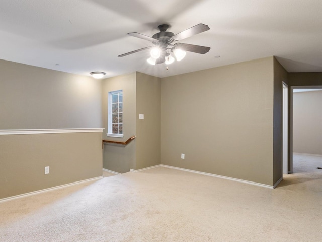 spare room featuring ceiling fan and light colored carpet