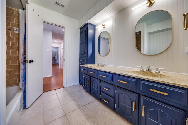 bathroom featuring double vanity, visible vents, a sink, and tile patterned floors