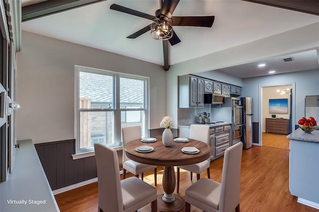 dining room featuring lofted ceiling, light wood-style floors, ceiling fan, and visible vents