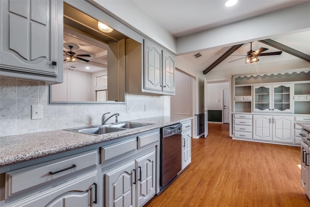 kitchen featuring vaulted ceiling with beams, a sink, visible vents, black dishwasher, and decorative backsplash