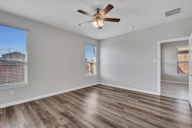 spare room with ceiling fan and dark hardwood / wood-style floors