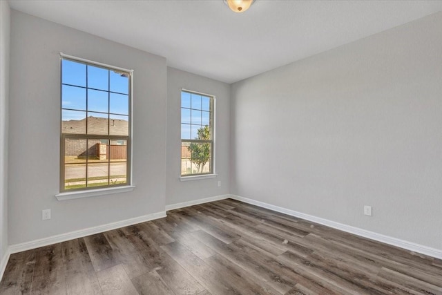 empty room featuring dark wood-type flooring and plenty of natural light