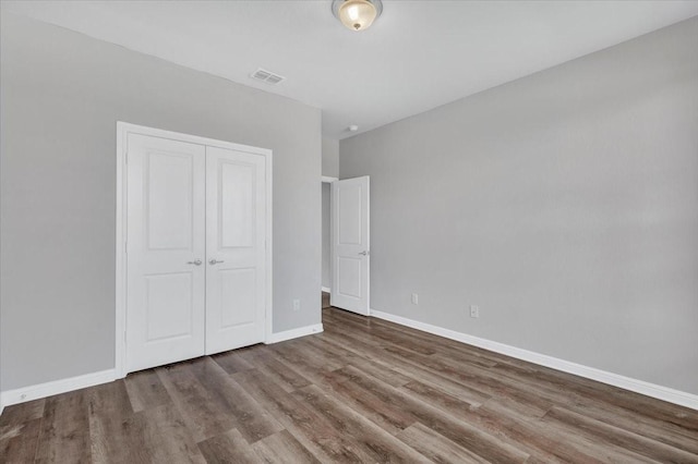 unfurnished bedroom with a closet and hardwood / wood-style floors