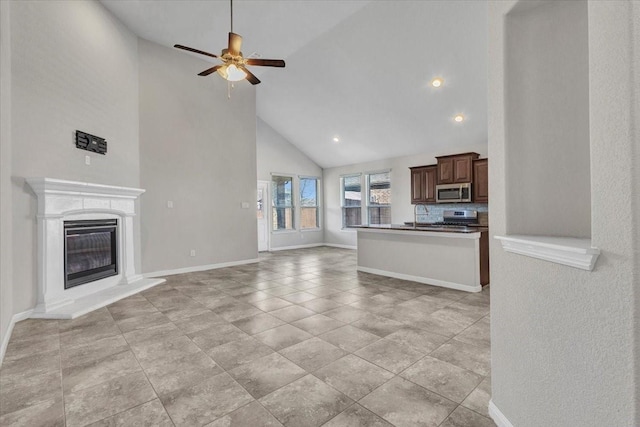 unfurnished living room featuring ceiling fan and high vaulted ceiling